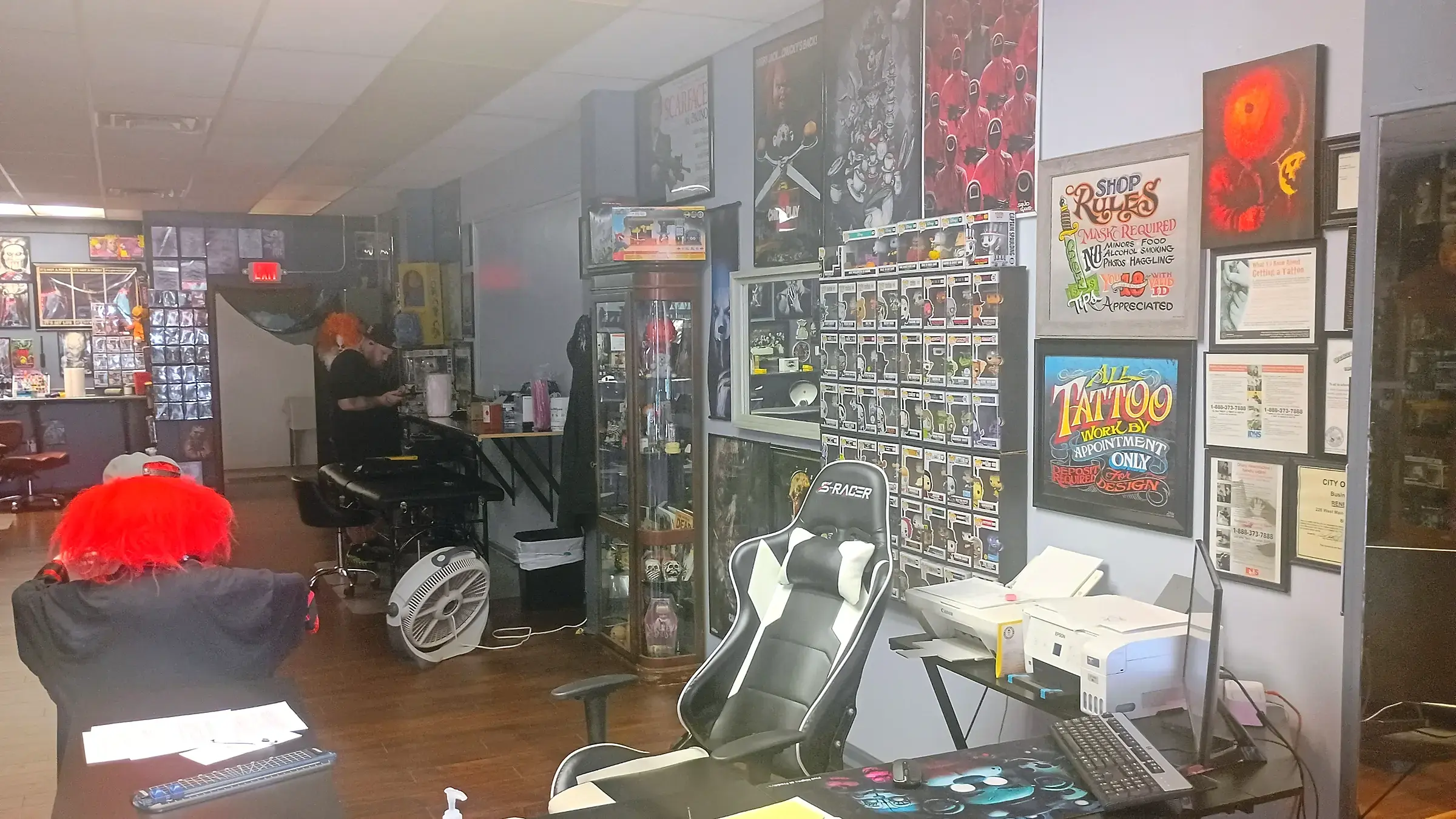 Rocco seated at his desk inside Renegade Ink, surrounded by tattoo art and collectibles